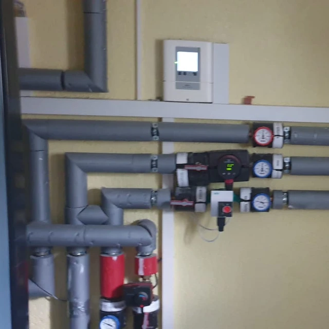 Foto von den Rohren und dem Zähler einer Wärmepumpe.
