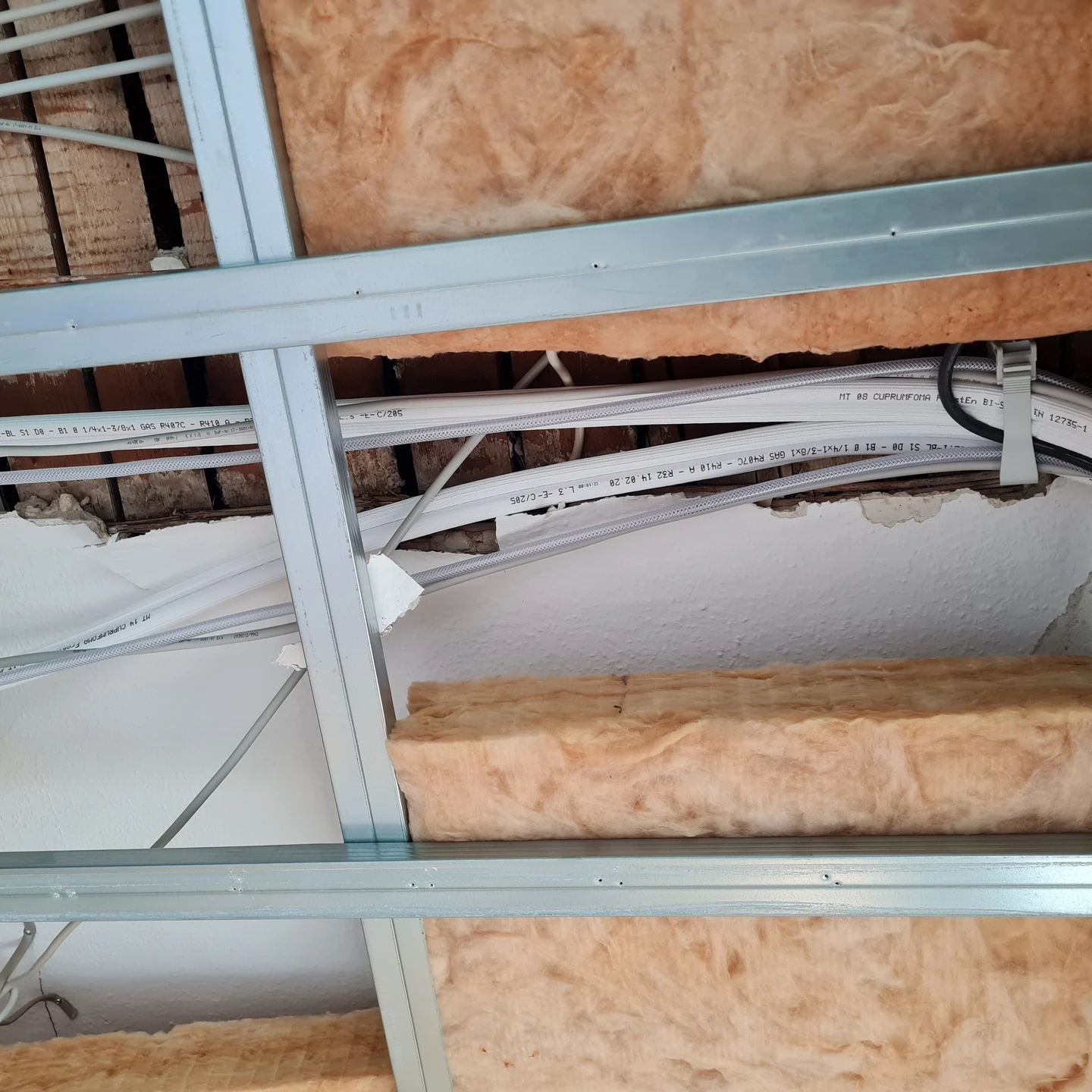 Foto von einer offenen Decke in der eine Klimaanlage eingebaut wird.